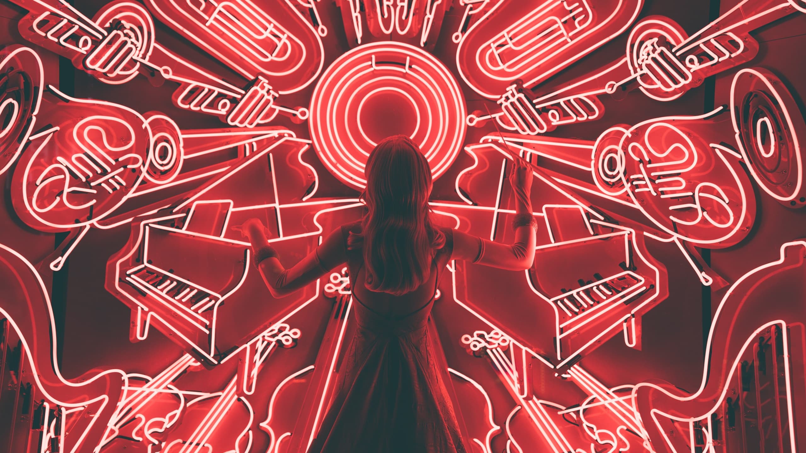 Woman staring at music symbols made out of florescent lighting