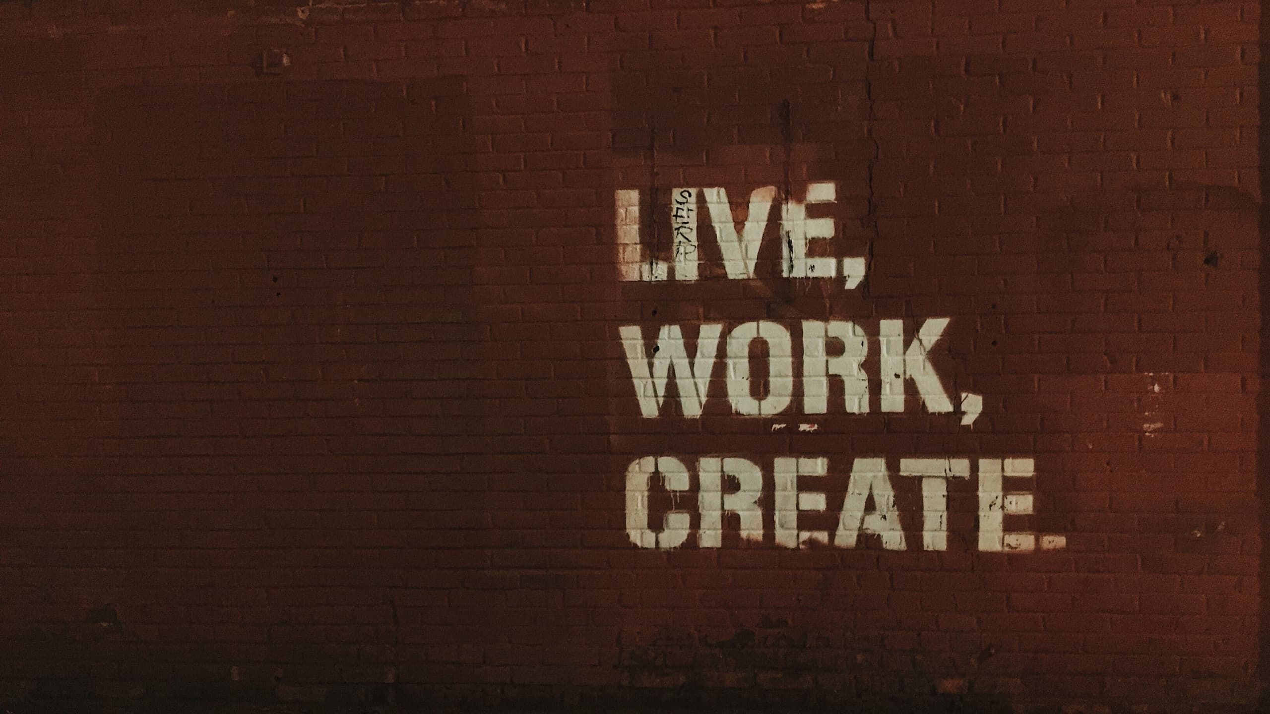Live, work, create on brick wall