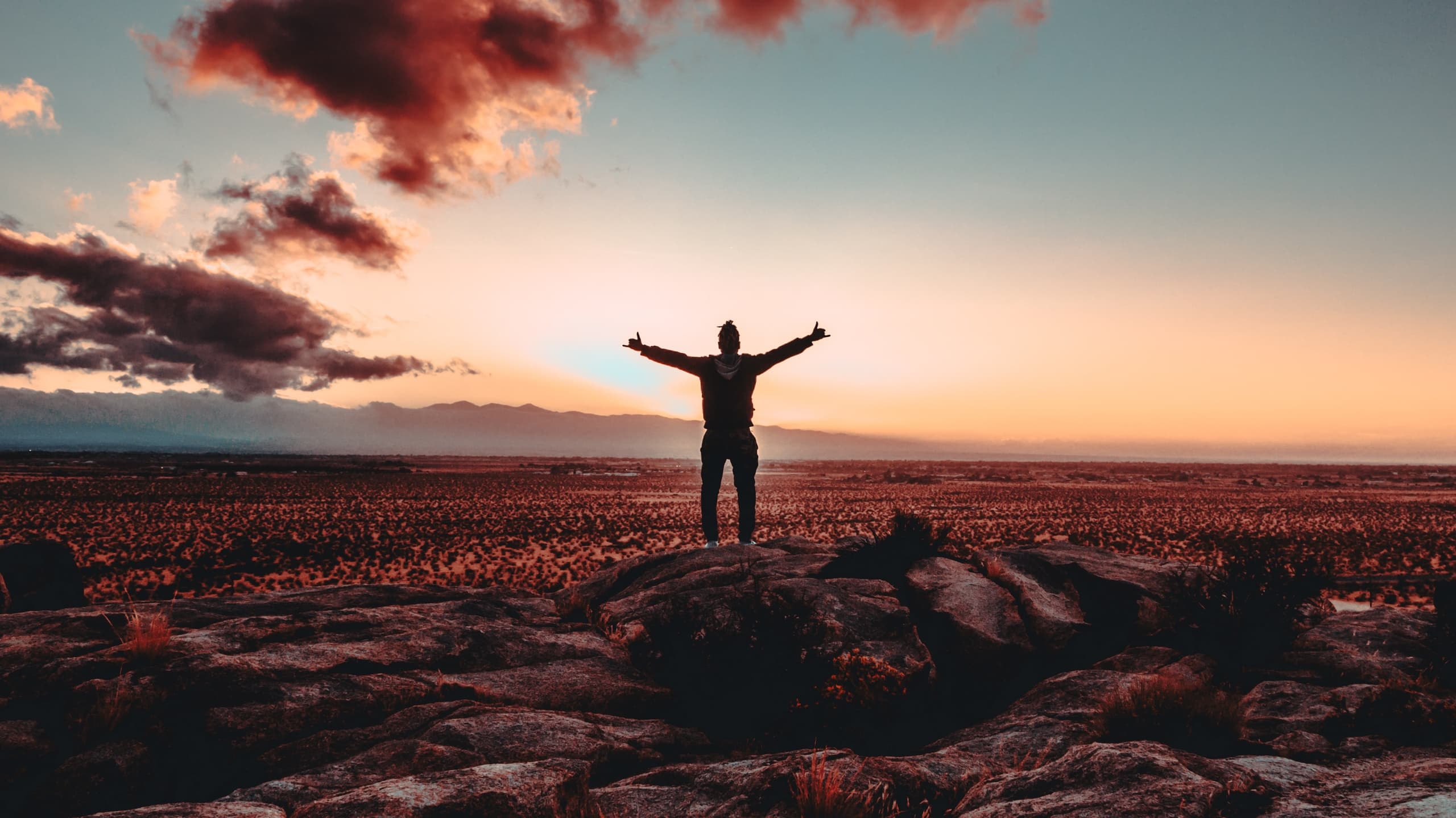 Man holding arms out standing on mountain