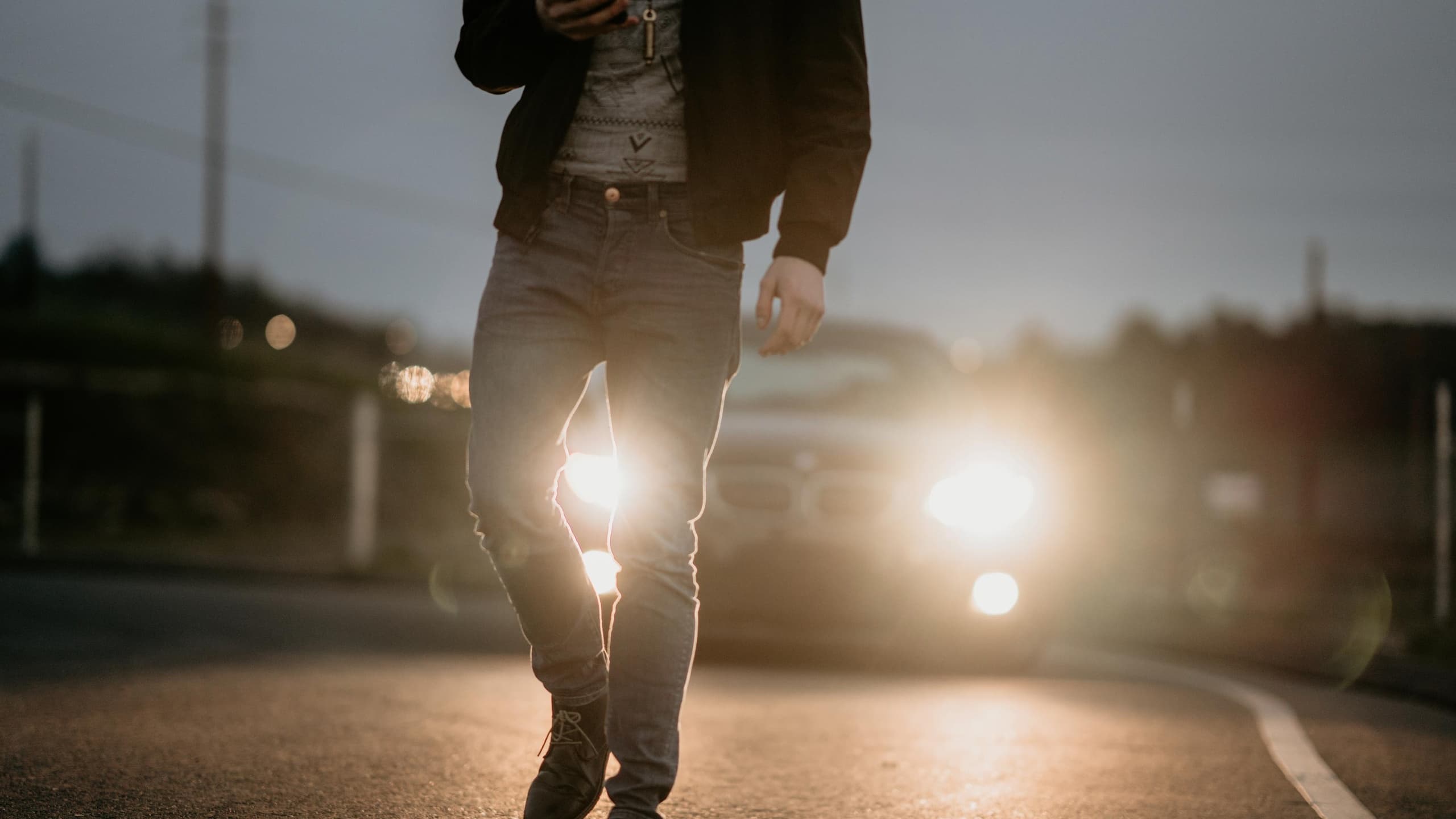 Man staring at phone near car