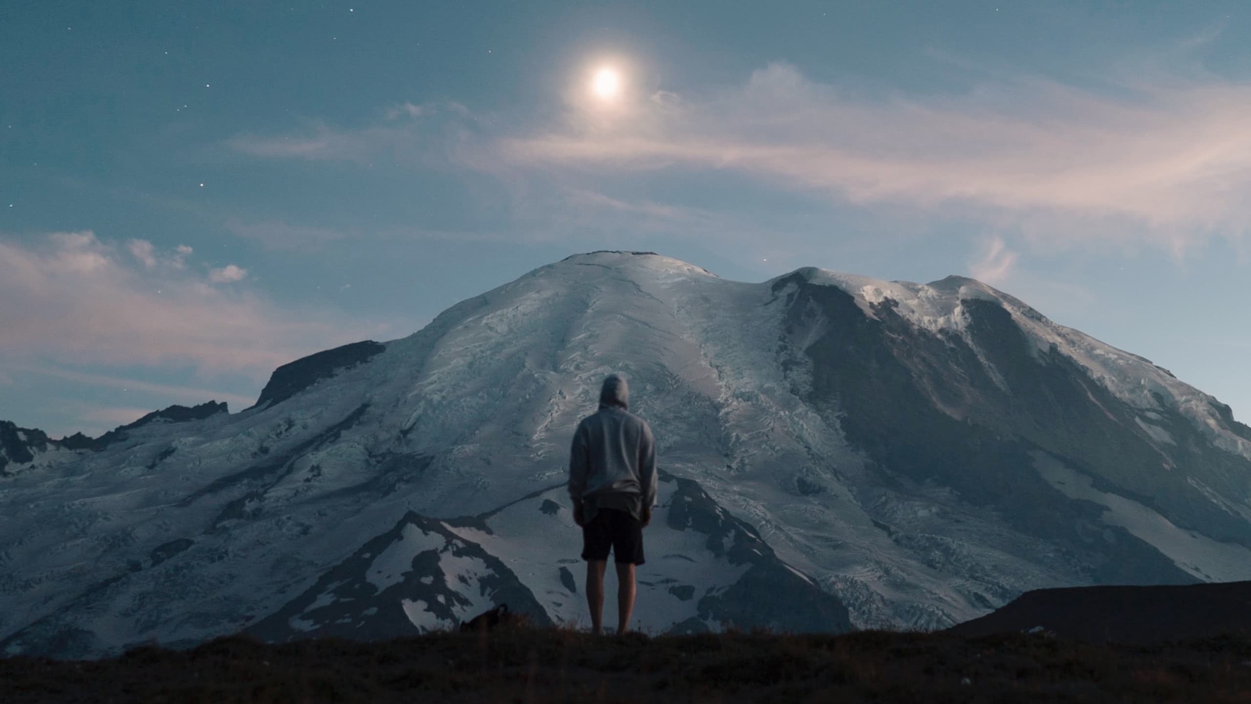 Man staring at sunset over mountaintop