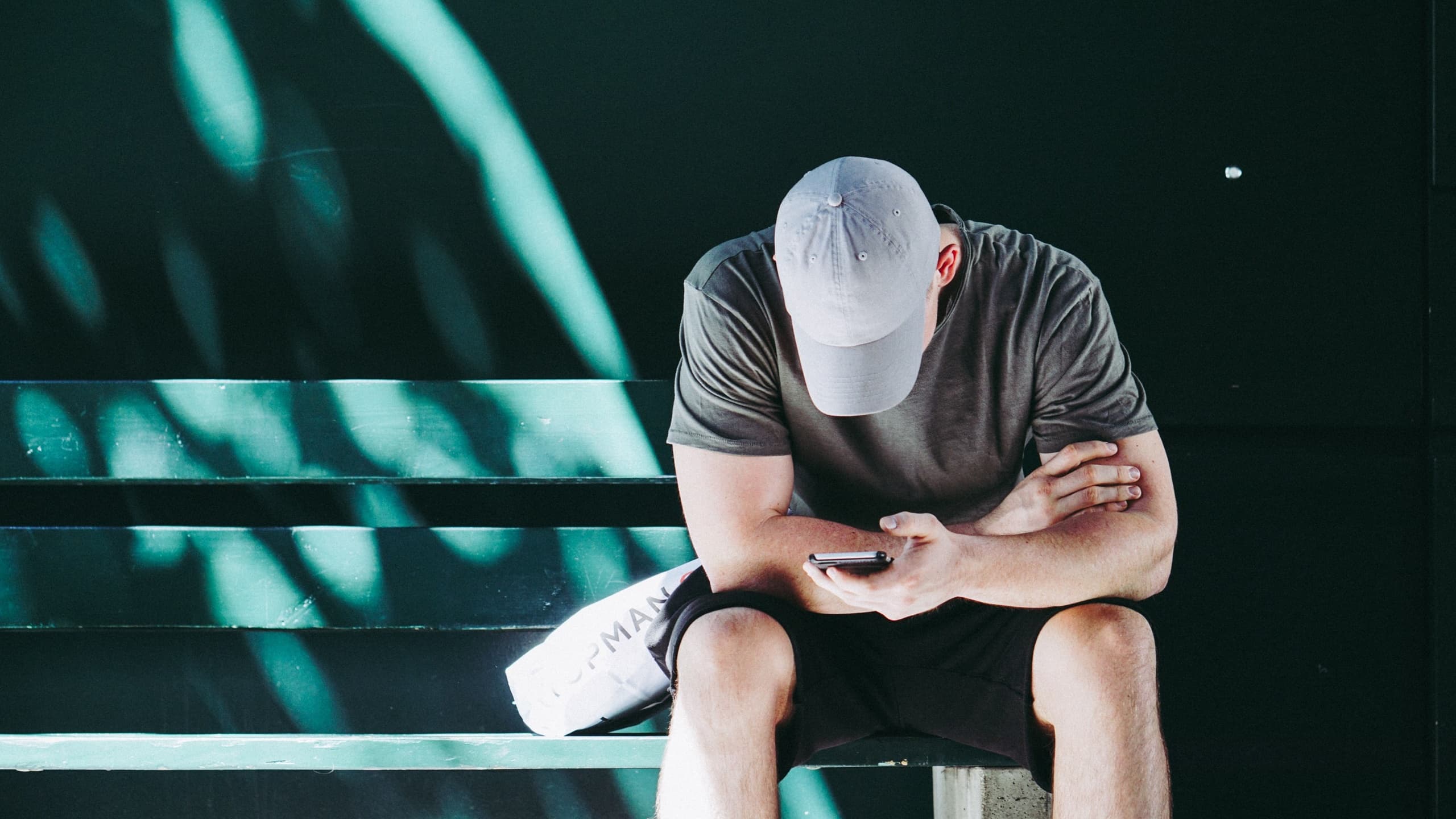 Man staring at phone while on bench