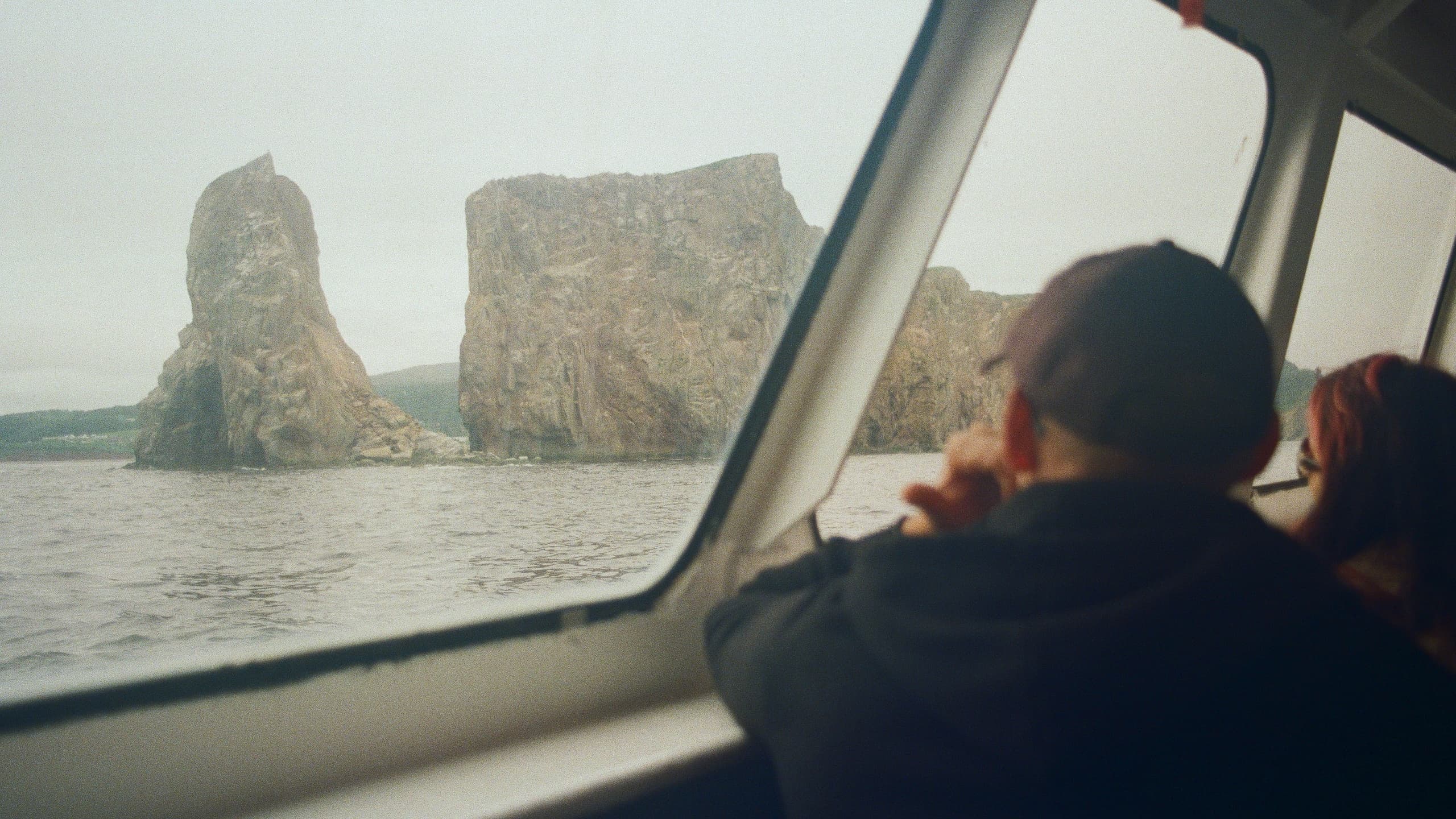 Man staring outside of boat at mountain