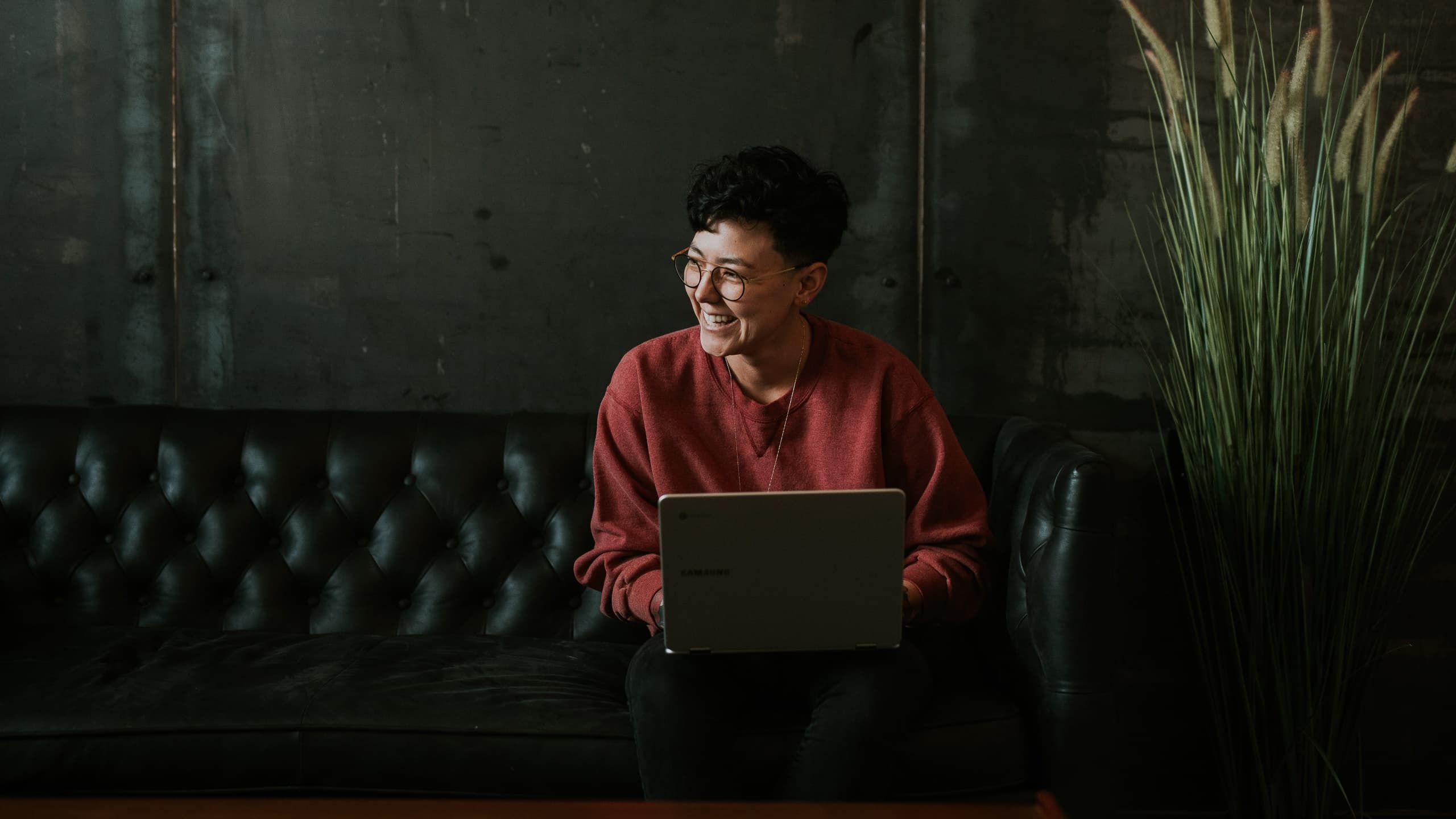 Woman typing on laptop while sitting on couch