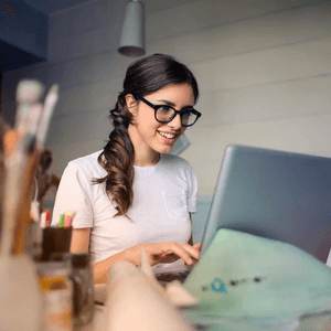 girl on laptop with paintbrushes